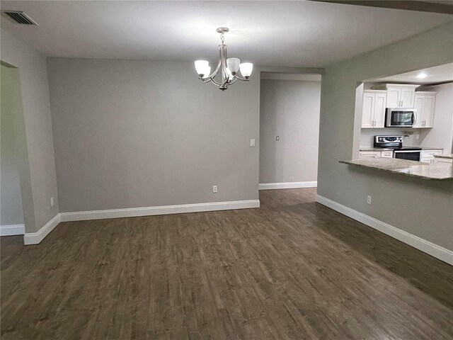 9526 SW 72nd Ct, Ocala, FL 34476 - unfurnished living room with dark wood-type flooring, a chandelier, and baseboards