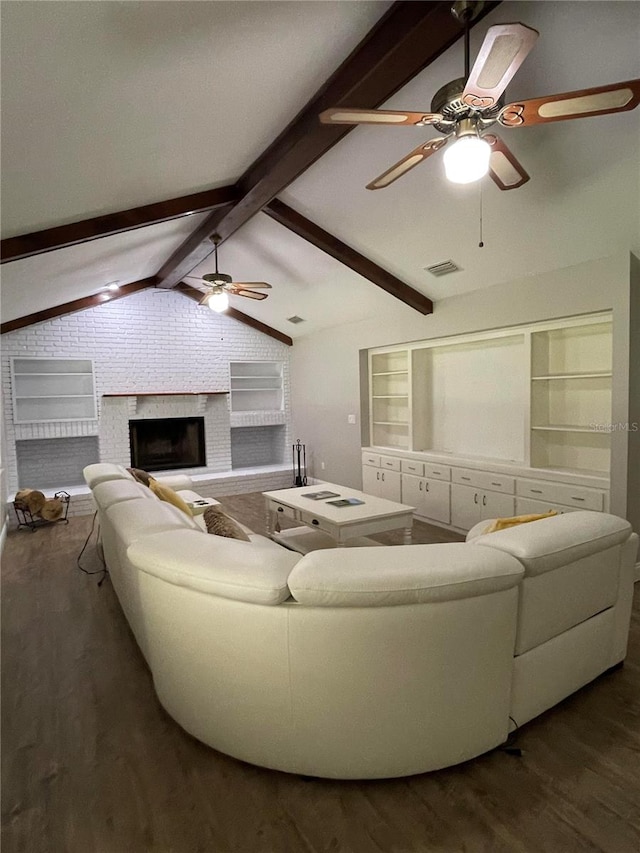 living room with vaulted ceiling with beams, ceiling fan, dark hardwood / wood-style floors, and a brick fireplace