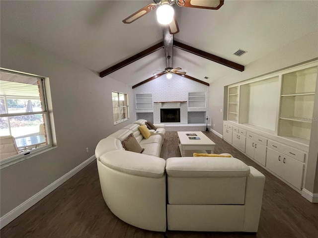 living room with ceiling fan, a brick fireplace, vaulted ceiling with beams, dark hardwood / wood-style flooring, and built in features