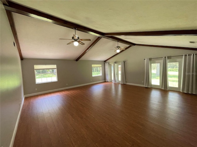 spare room featuring vaulted ceiling with beams, a wealth of natural light, ceiling fan, and dark hardwood / wood-style floors