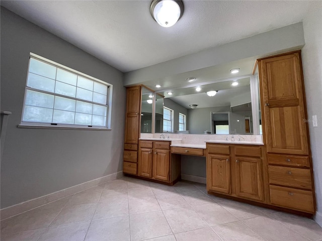 bathroom with tile patterned flooring, a textured ceiling, and vanity