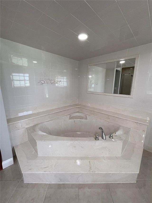 bathroom featuring tiled bath and tile patterned floors