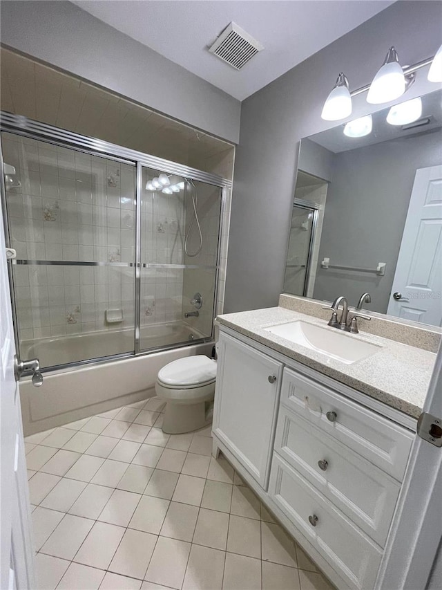 full bathroom featuring tile patterned floors, vanity, bath / shower combo with glass door, and toilet