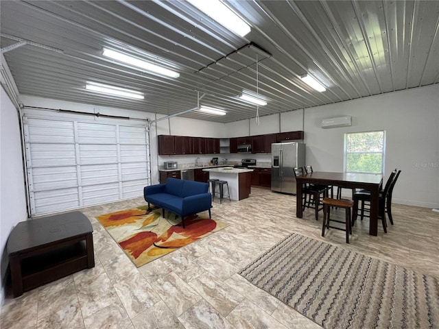 interior space with an AC wall unit, sink, and stainless steel refrigerator with ice dispenser