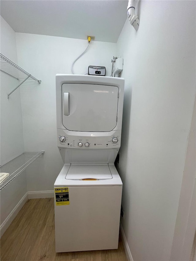 9526 SW 72nd Ct, Ocala, FL 34476 - laundry area featuring stacked washer / dryer, wood finished floors, and baseboards