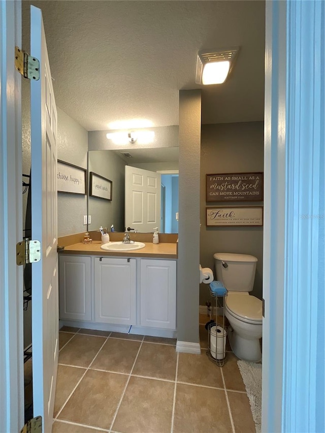 bathroom with vanity, tile patterned flooring, toilet, and a textured ceiling