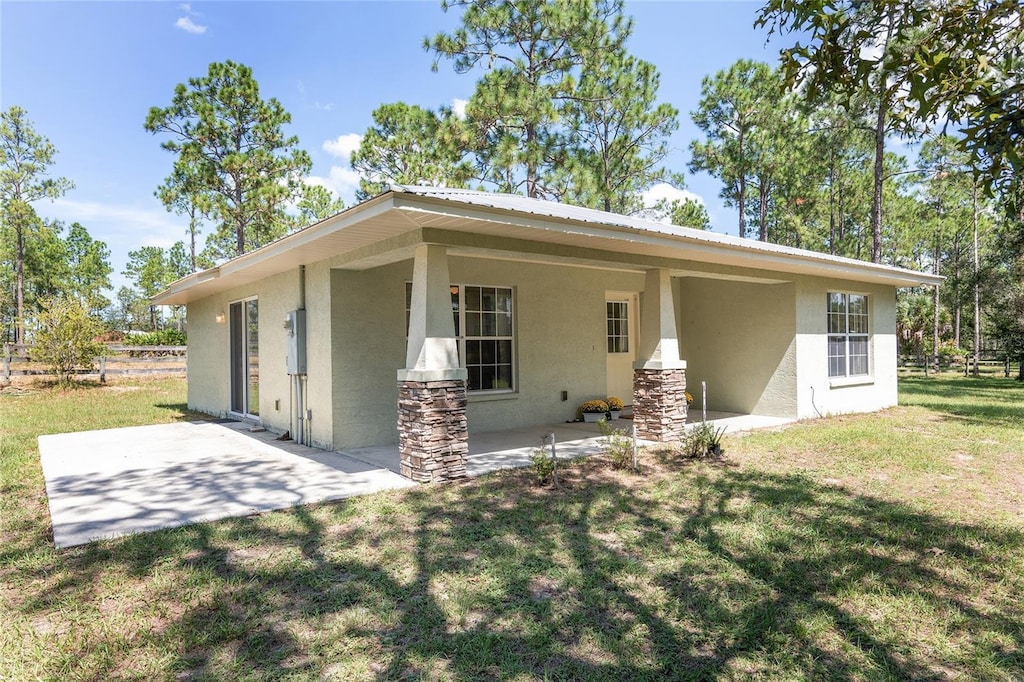 rear view of property with a patio and a yard