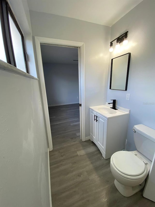 bathroom with hardwood / wood-style floors, vanity, and toilet