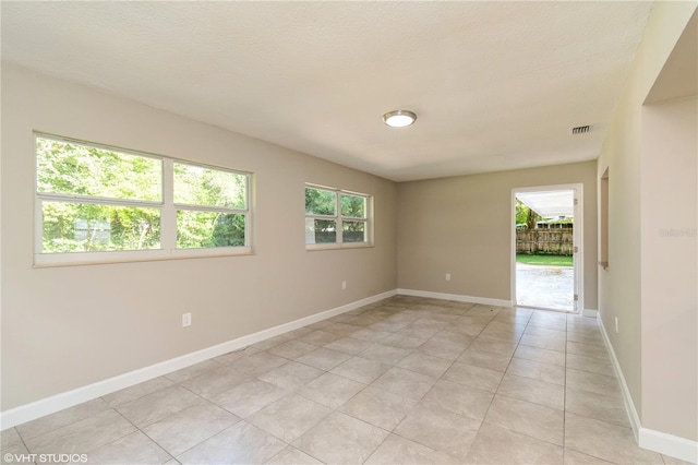 tiled spare room with a textured ceiling