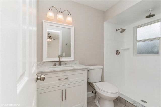 bathroom with ceiling fan, vanity, toilet, and tiled shower