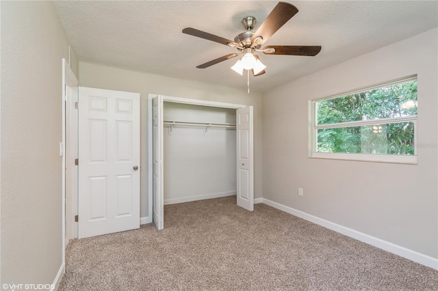 unfurnished bedroom with a closet, ceiling fan, carpet floors, and a textured ceiling