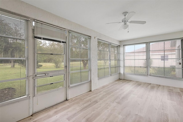 unfurnished sunroom with ceiling fan