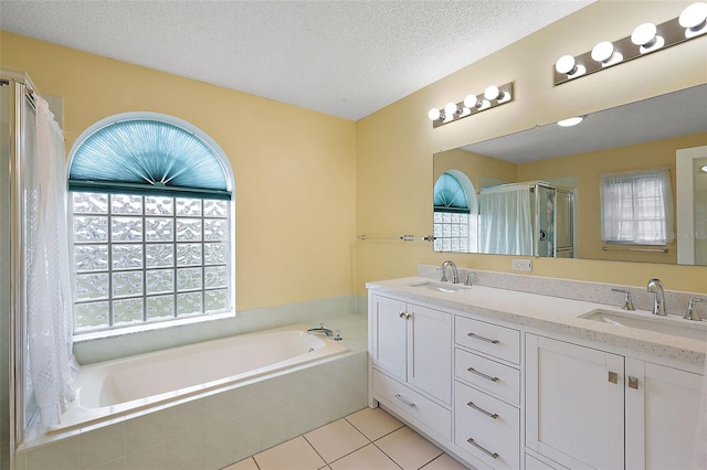 bathroom with a wealth of natural light, a textured ceiling, and vanity