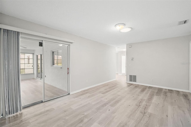 empty room with light hardwood / wood-style floors and a textured ceiling