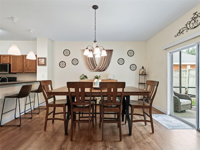 dining room with hardwood / wood-style flooring and a chandelier