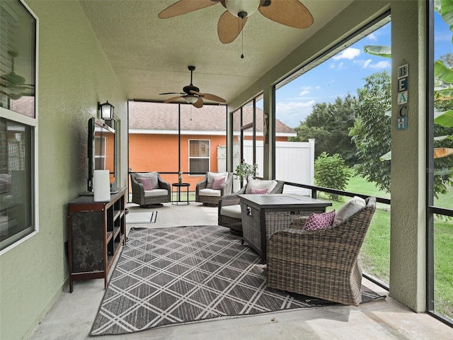 sunroom / solarium featuring plenty of natural light and ceiling fan