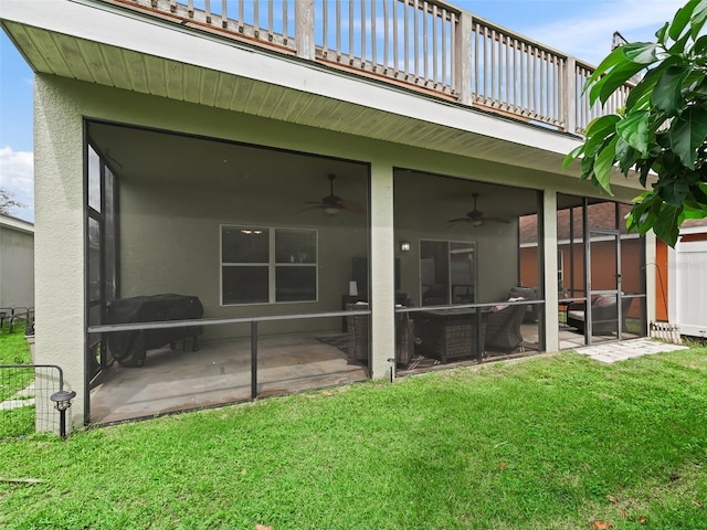 back of house with a lawn, ceiling fan, a patio area, and a balcony