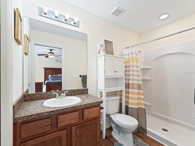 bathroom featuring hardwood / wood-style floors, vanity, toilet, and walk in shower