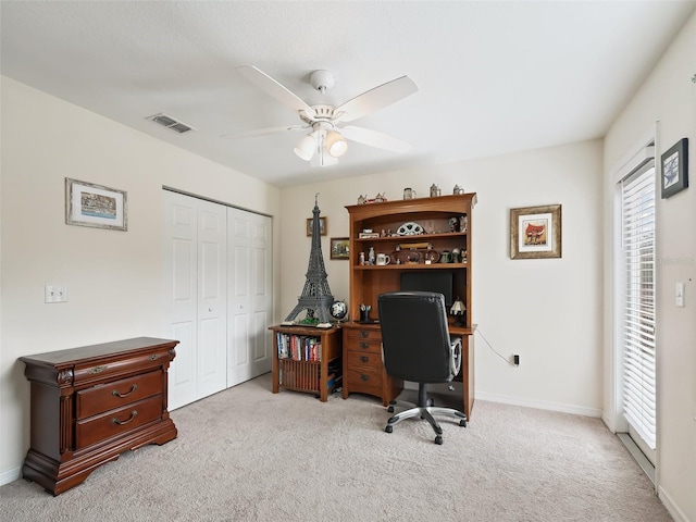 home office featuring light carpet and ceiling fan