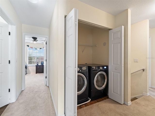 laundry room featuring washer and dryer, ceiling fan, and light carpet