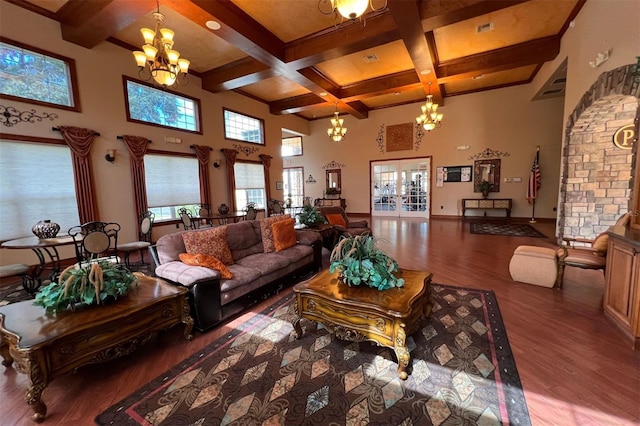 living room with plenty of natural light, dark wood-type flooring, a high ceiling, and coffered ceiling