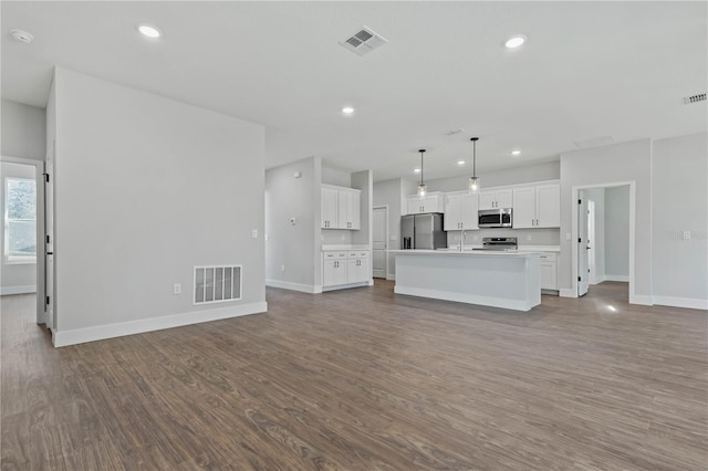 unfurnished living room featuring wood-type flooring and sink