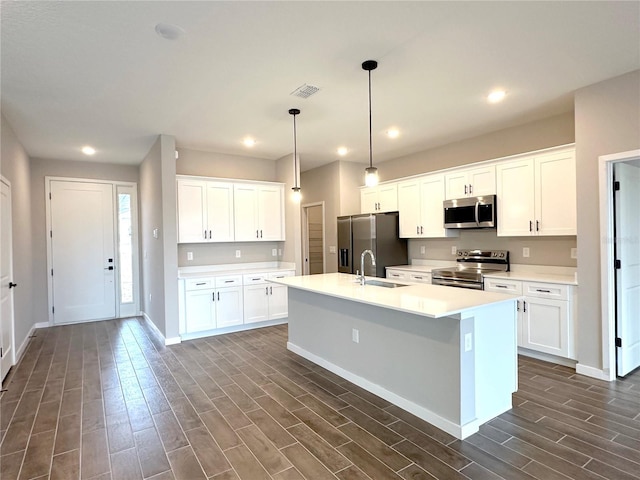 kitchen with stainless steel appliances, light countertops, and white cabinetry