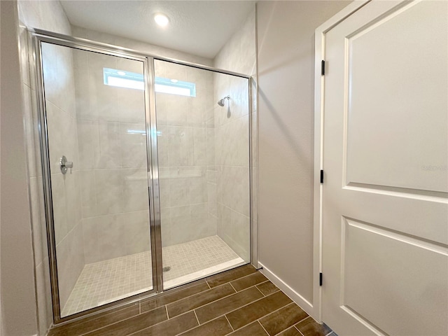 full bath with wood finish floors and a shower stall