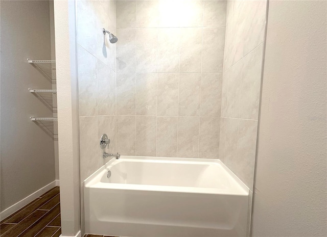 full bathroom featuring wood finish floors, baseboards, and shower / bathtub combination