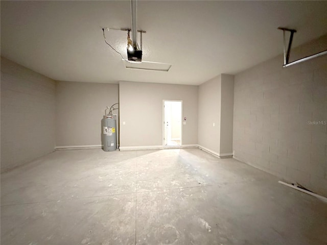 garage featuring concrete block wall, electric water heater, and a garage door opener