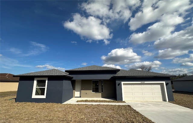 view of front of home featuring a garage, driveway, a shingled roof, and stucco siding