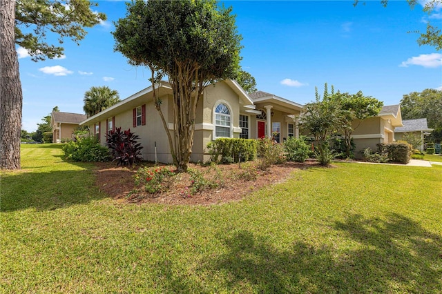 single story home featuring stucco siding and a front lawn