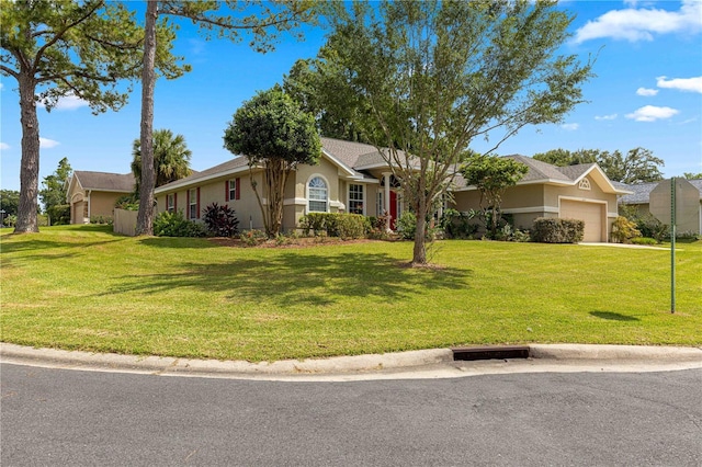 ranch-style house featuring an attached garage, stucco siding, and a front yard