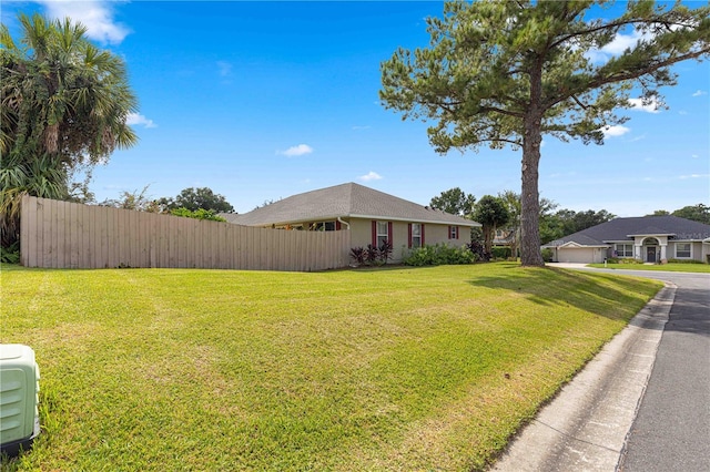exterior space with fence and a lawn