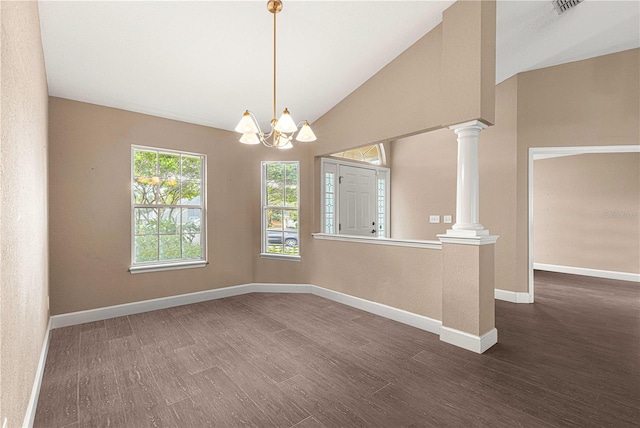 empty room featuring a notable chandelier, vaulted ceiling, decorative columns, and dark wood-type flooring