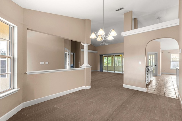 spare room featuring a notable chandelier, lofted ceiling, plenty of natural light, and dark hardwood / wood-style flooring