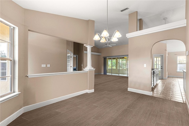 interior space with arched walkways, plenty of natural light, an inviting chandelier, and wood finished floors