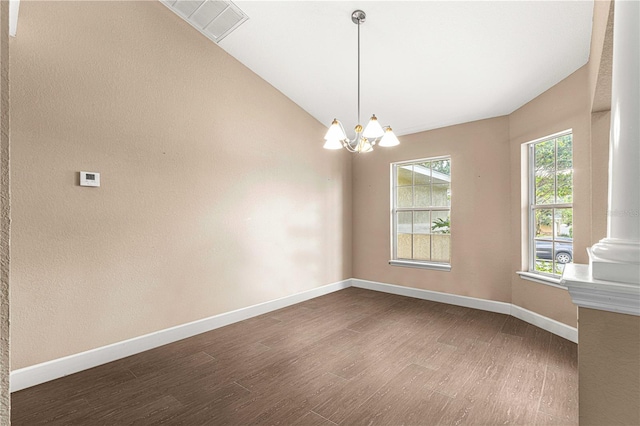 empty room with visible vents, baseboards, an inviting chandelier, wood finished floors, and lofted ceiling