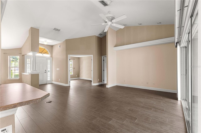 unfurnished living room featuring ornate columns, dark hardwood / wood-style flooring, high vaulted ceiling, and ceiling fan