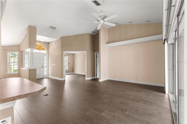 unfurnished living room with decorative columns, visible vents, a ceiling fan, and dark wood-style floors