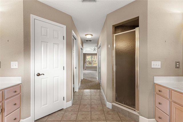 bathroom featuring tile patterned flooring, vanity, and a shower with shower door