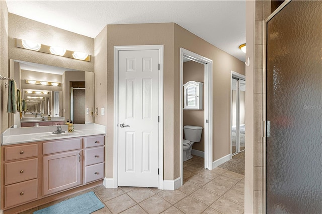 bathroom with vanity, an enclosed shower, a textured ceiling, tile patterned floors, and toilet