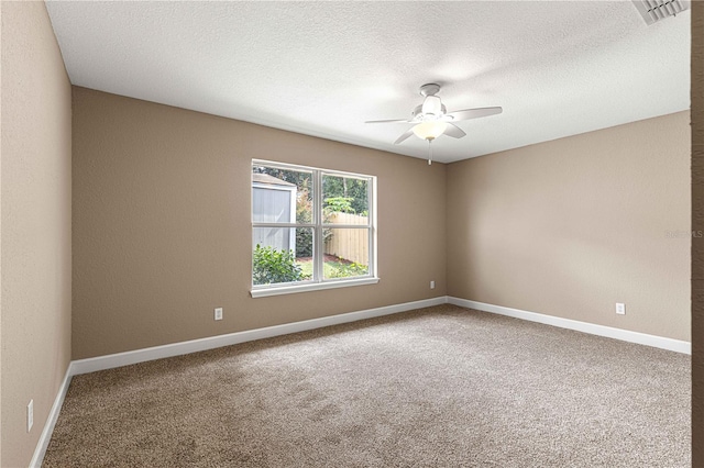 empty room featuring baseboards, a textured ceiling, a ceiling fan, carpet floors, and visible vents