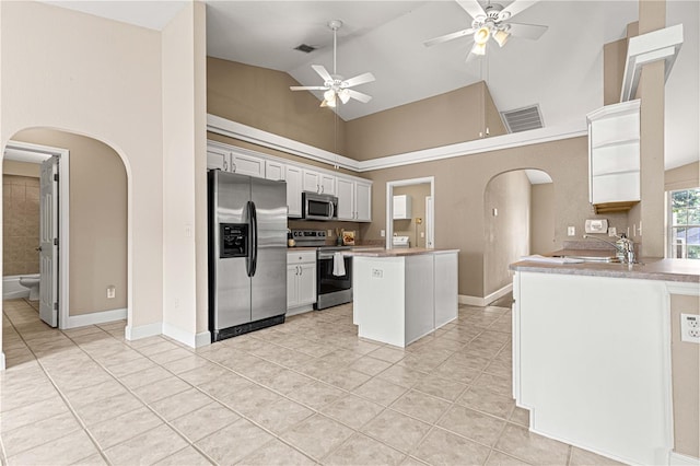 kitchen featuring white cabinetry, high vaulted ceiling, stainless steel appliances, light tile patterned floors, and ceiling fan