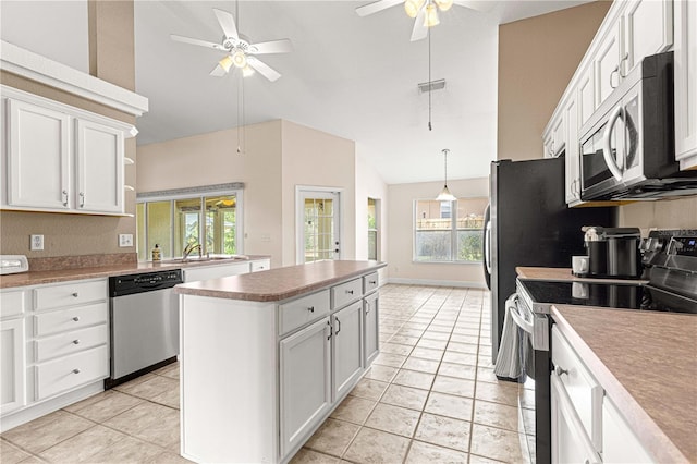 kitchen with stainless steel appliances, white cabinets, a wealth of natural light, and ceiling fan