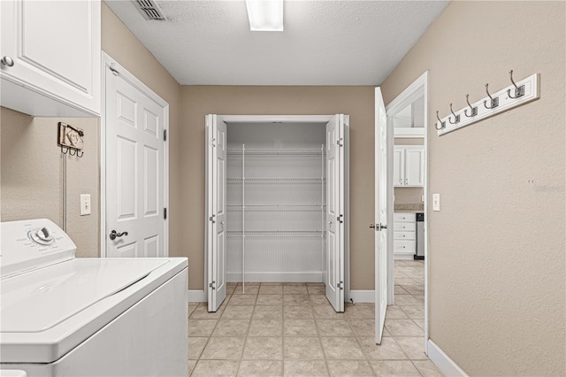 laundry room featuring washer / clothes dryer, baseboards, visible vents, a textured ceiling, and cabinet space