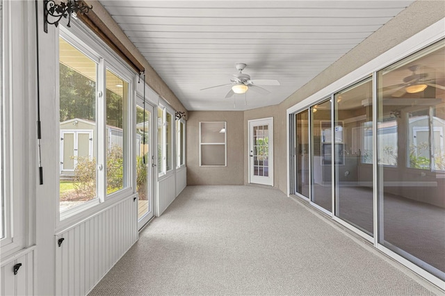 unfurnished sunroom featuring ceiling fan