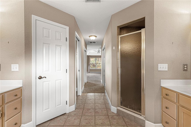 bathroom with vanity, visible vents, a stall shower, baseboards, and tile patterned floors