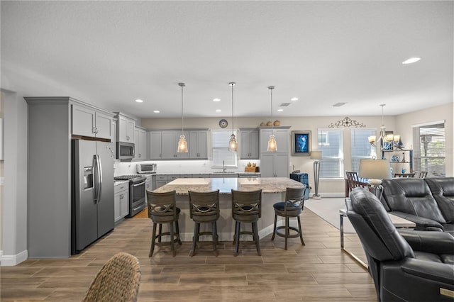 dining space featuring wood-type flooring, an inviting chandelier, and sink