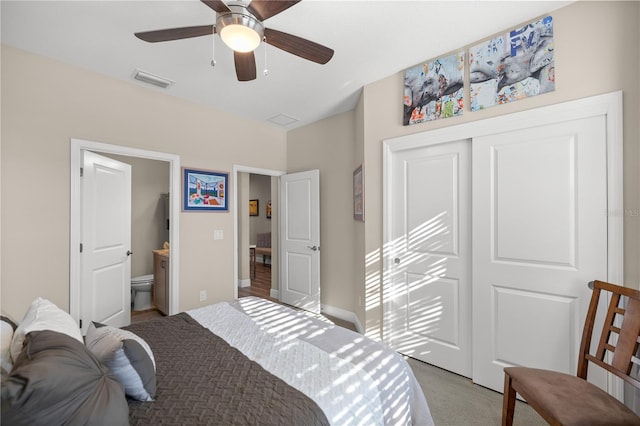 carpeted bedroom with a closet, ceiling fan, and ensuite bathroom